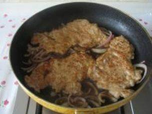 日式猪排饭,油锅放入洋葱炒软,倒入酱汁,中火煮开后放入煎过的猪排卤一下