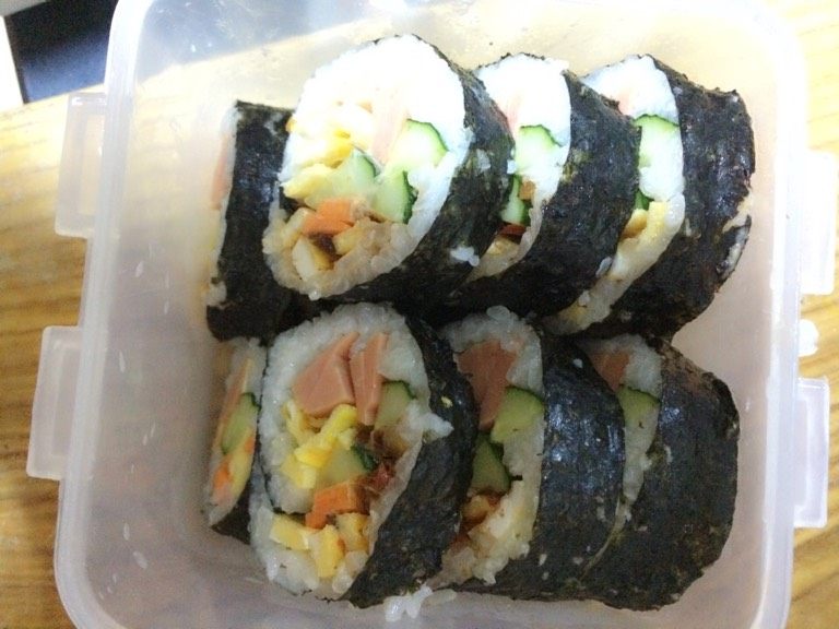 紫菜包饭,卷成圆柱长条，刀沾水切开，码入盘中