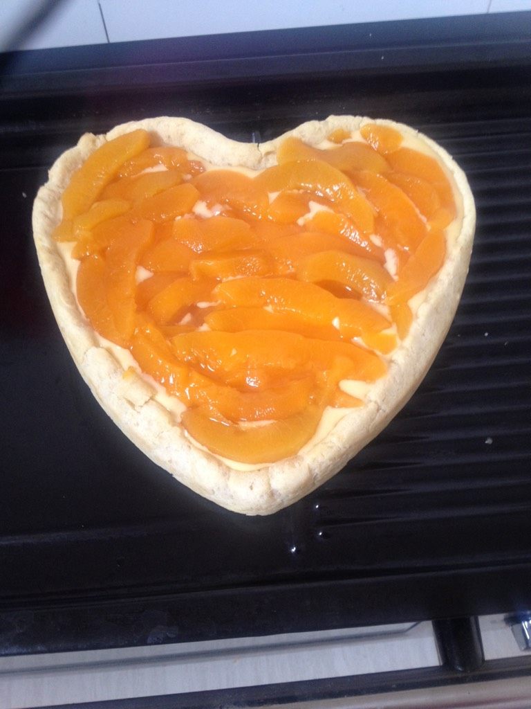 经典黄桃派,如图均匀铺上切好的黄桃片；