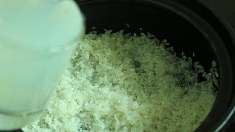 醋拌蛤蜊拌饭,将2杯大米洗净后倒入砂锅中,加入2杯蛤蜊汤