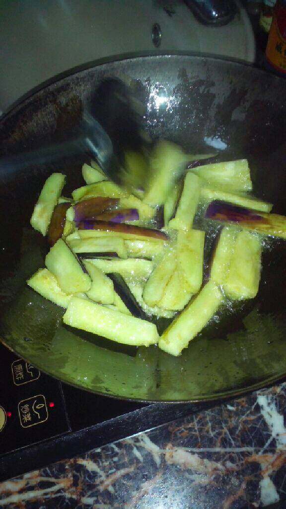 自创(咸鱼茄子煲),锅里放油(多点)把茄子放进去炸。