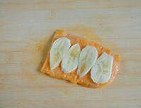 奥尔良奶酪鸡排,取出平铺在案板上，去掉不规则的边缘，铺上香蕉片