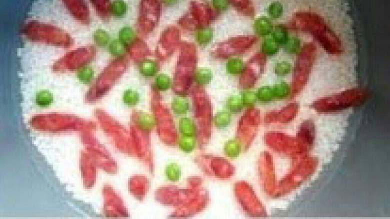 【DIY香肠焖米饭】,焖制10分钟左右，打开盖子，加入香肠片，豌豆，