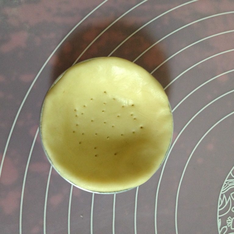 迷你苹果派,用份量多的那张派皮放进模具里按压贴合,用牙签在底部叉些小孔
