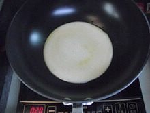 披萨蛋饼,不粘锅刷一层薄油,开小火,倒入全部蛋糊,铺平锅底。