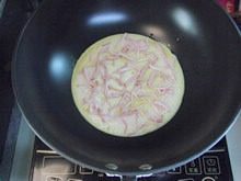 披萨蛋饼,大概40秒以后,把火关掉,在蛋糊面上轻轻铺上培根丝。