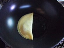 苹果鸡蛋饼,用锅铲把整张蛋皮对半对折,再轻轻把边缘压紧。