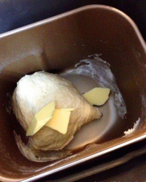 饱含粮食的香气：大米面包,第一次揉面结束后，放入黄油