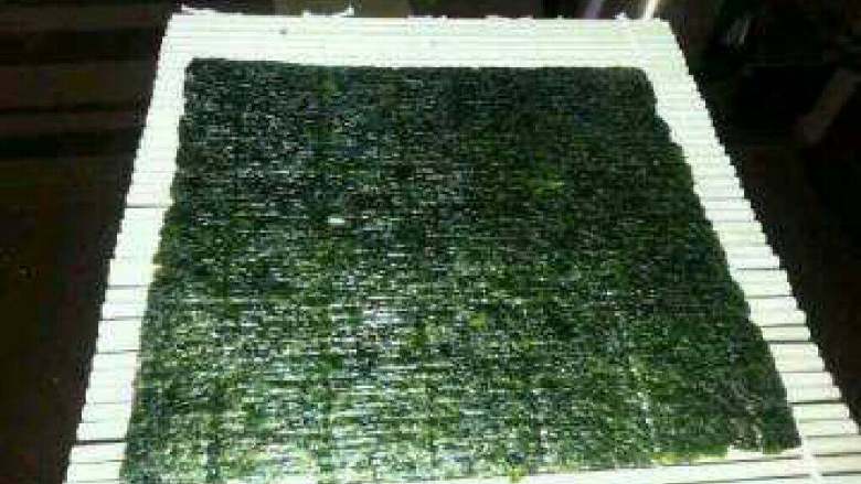 自制简单美味的寿司,在寿司卷放海苔片（超市有卖）