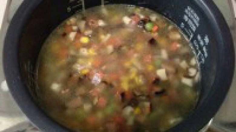 电饭锅煲仔饭,饭煲一半熟打开盖子把炒好的材料都放进去一起煲。