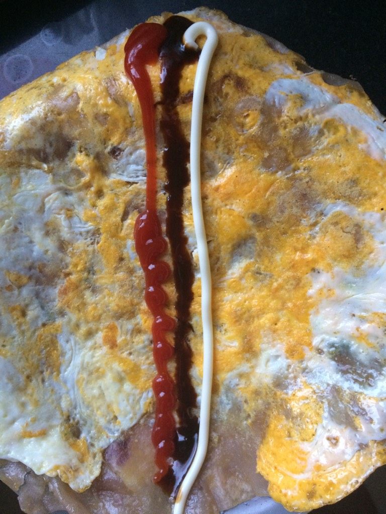 鸡蛋卷饼,将平底锅烧热倒入<a style='color:red;display:inline-block;' href='/shicai/ 849'>花生油</a>，待油六成热将火调最小，打入整个鸡蛋，迅速拿筷子将鸡蛋搅匀，拿饼覆盖在鸡蛋液上旋转饼皮，让鸡蛋均匀沾在饼皮上，调中火煎制鸡蛋熟透，盛出，挤上<a style='color:red;display:inline-block;' href='/shicai/ 4856'>沙拉酱</a>，<a style='color:red;display:inline-block;' href='/shicai/ 712'>甜面酱</a>，<a style='color:red;display:inline-block;' href='/shicai/ 699'>番茄酱</a>