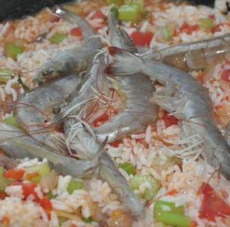 什锦海鲜焗饭,加入少许水等开后加入米饭炖煮3分钟,放入虾,盖上盖子小火焖3分钟