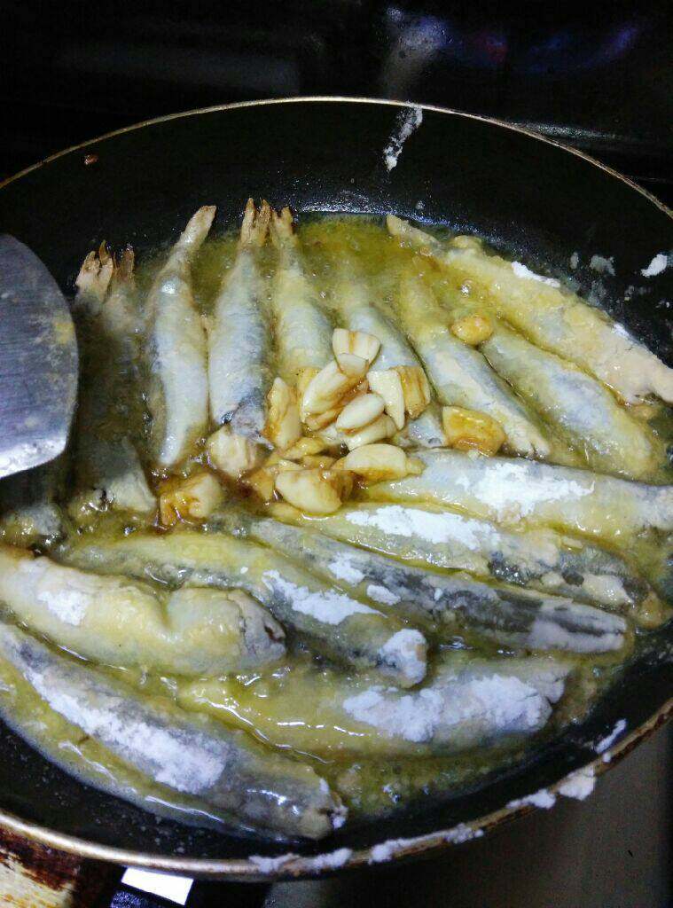 香煎多春鱼,平底锅煎鱼,把之前腌鱼的蒜头一起煎,这样既不浪费,又香