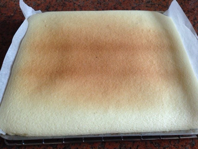 巧克力波点蛋糕卷,取出烤盘后往油纸倒入面糊,轻轻振动几下,放进已预热的烤箱用160度烤15~18分钟取出