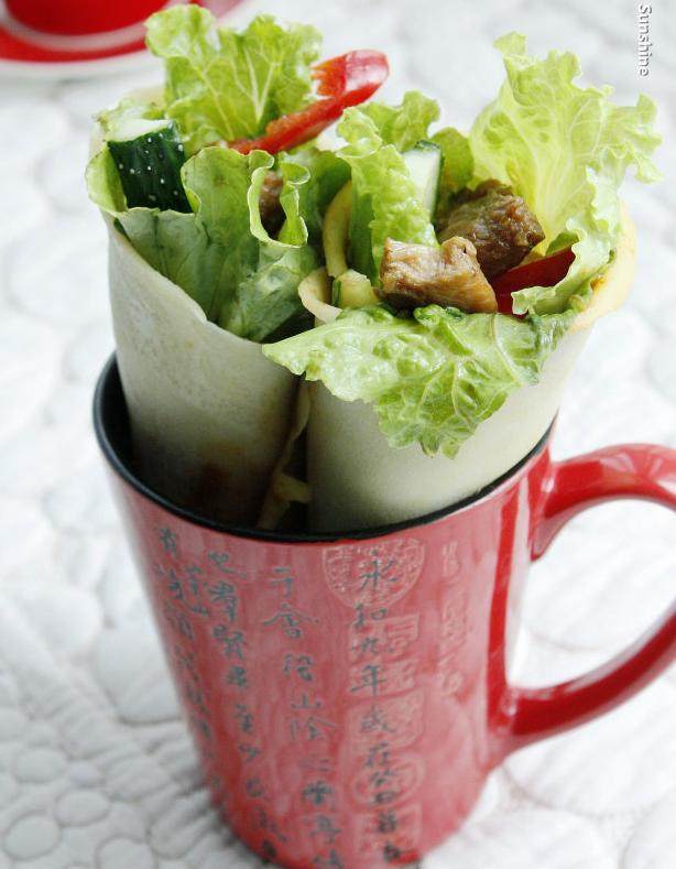 鸡腿卷饼,在饼底上刷一层<a style='color:red;display:inline-block;' href='/shicai/ 4510'>黄豆酱</a>，再依次摆上<a style='color:red;display:inline-block;' href='/shicai/ 121'>生菜</a>、黄瓜条和红椒条，放上鸡肉，卷起就可以享受美味啦