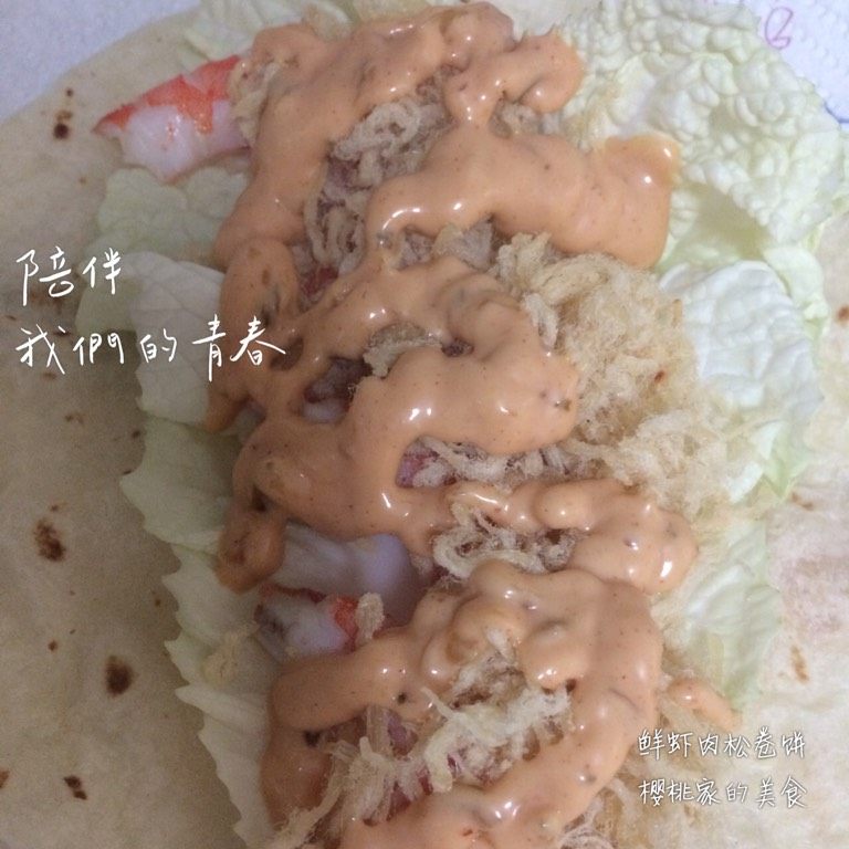 鲜虾肉松卷饼,烙饼平摊在厨房纸上，依次将<a style='color:red;display:inline-block;' href='/shicai/ 121'>生菜</a>、剥好皮的虾、<a style='color:red;display:inline-block;' href='/shicai/ 432'>肉松</a>放在饼胚上，挤上<a style='color:red;display:inline-block;' href='/shicai/ 10273'>千岛酱</a>，再卷起来即可。