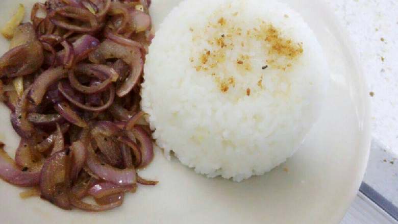 猪排饭,盘里准备好米饭(可洒些芝麻做装饰),将黑胡椒洋葱摆在饭旁边。