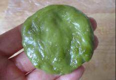 椰丝抹茶团,放入锅中蒸熟；放凉后，再在手上抹点油，拿出一小团面按压为圆片
