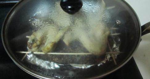 茶香熏鸡翅,盖上锅盖,开大火,待热气传递到锡纸盒,将上面的糖热后开始冒烟,转为小火