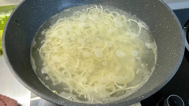 雪碧拌面,水再次开,下面条,筷子搅散,中小火煮两分钟,捞出过凉沥水备用