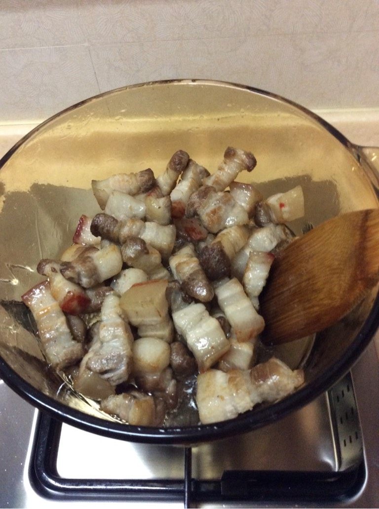 笋干菜烧肉,干锅上灶不加油,沥干水分的五花入热锅慢火炒至出油。