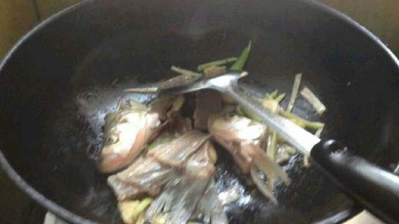 香煎嫩豆腐刁子鱼,鱼头没有炸,放进锅里翻炒一下。