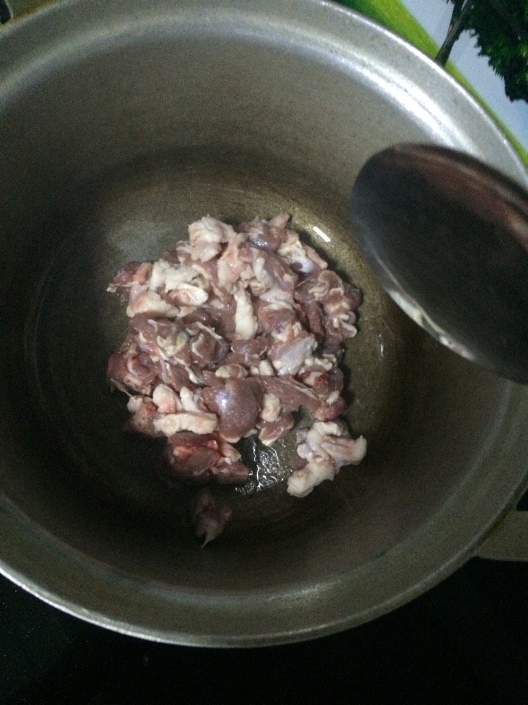 羊肉手抓饭,如图用铝锅烧热,倒入少许食用油煸炒羊肉丁