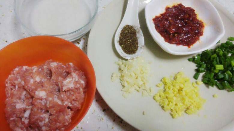 麻婆豆腐,姜、蒜切成末,葱切成葱花。
猪肉切成末,倒入少量料酒腌制;。
淀粉调成芡汁备用。