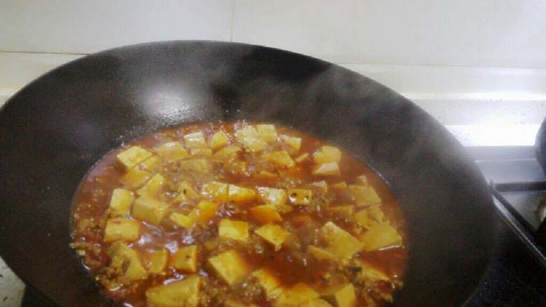 麻婆豆腐,大火烧开后,转为小火,盖上盖子焖烧5分钟。
大火煮五分钟左右,调入盐味和鸡精。