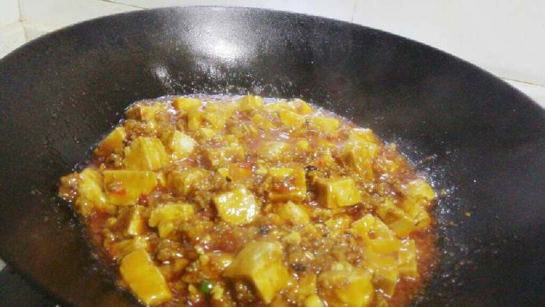 麻婆豆腐,兑入芡汁,撒入葱花和适量<a style='color:red;display:inline-block;' href='/shicai/ 12043'>花椒粉</a>,略翻炒一下即可出锅。