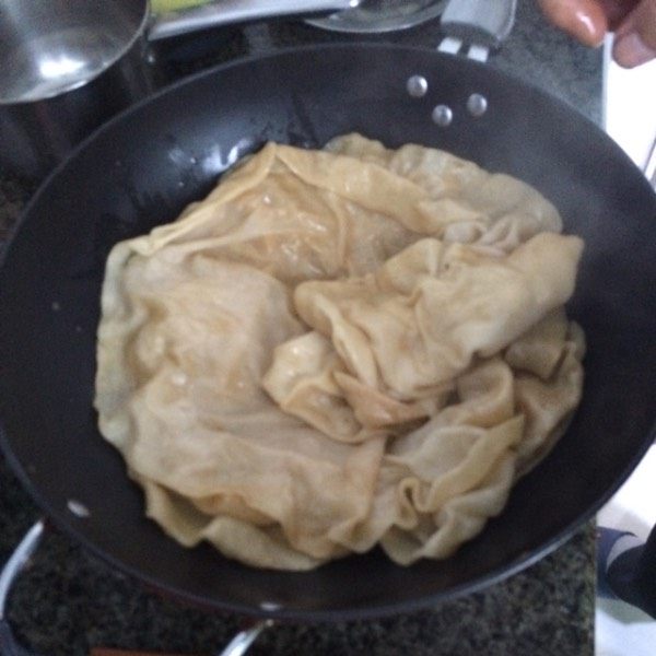 羊肉焖饼子,将饼子用筷子夹出,放到盘子里。