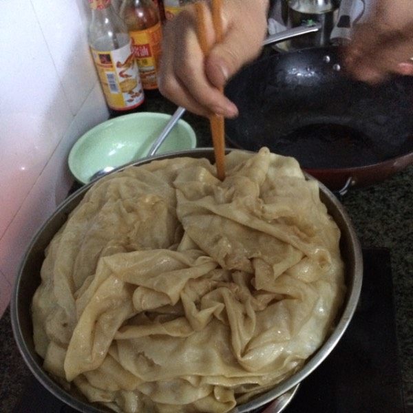 羊肉焖饼子,最后将焖好的饼子在铺到肉上，将前面乘出来的汤汁均匀的倒在饼子上，盖上锅盖继续炖十五分钟。