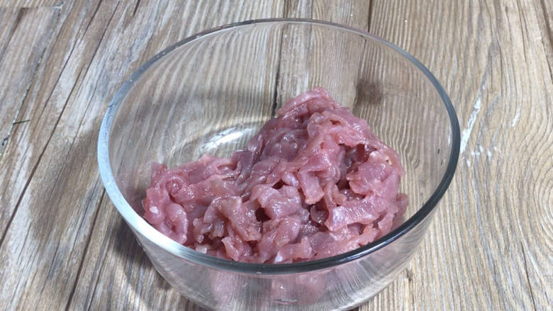 芹菜木耳炒肉丝,瘦肉片成薄片,叠加起来切成细丝,装入容器中