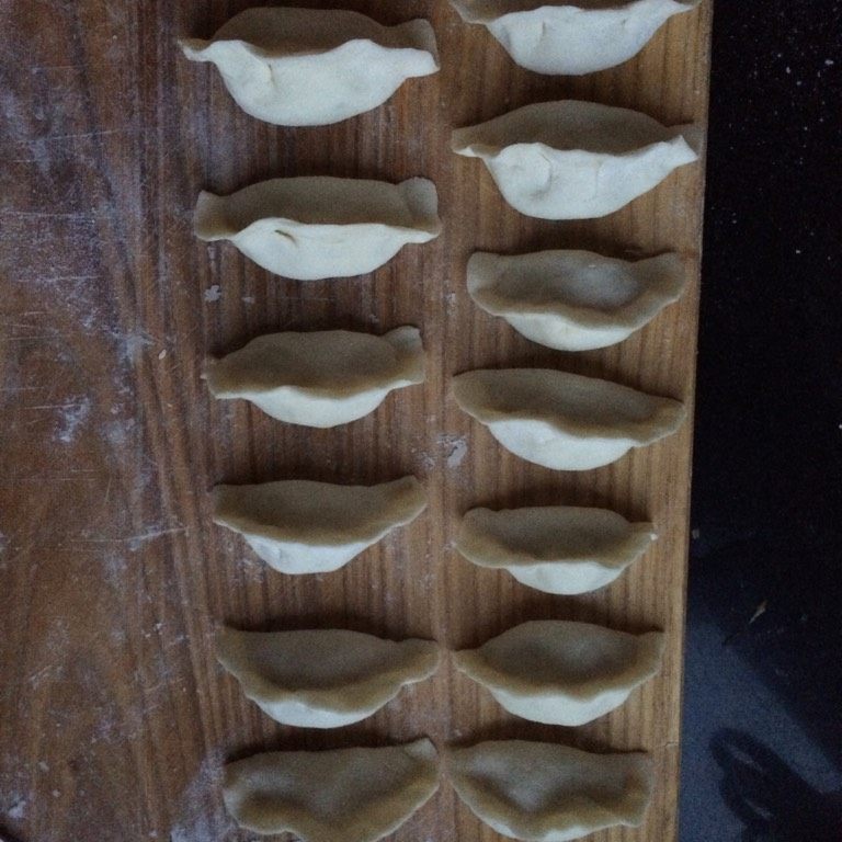 冰花牛肉马蹄水煎饺,如图将肉馅儿包入面皮中捏紧口,直立放好醒发二十分钟