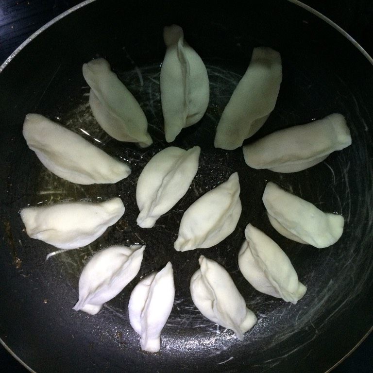冰花牛肉马蹄水煎饺,如图平底锅烧热,倒少许食用油,待油七分热将饺子胚留出空隙均匀的放在锅底,中火,待表皮差不多煎熟