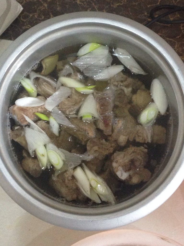 骨头汤,注意捞去浮沫。捞的差不多了，整锅倒出。重新烧一锅水，烧开，放入料酒，大葱，姜片，基本熟了的肉骨头，以及萝卜块，香菇。炖15分钟进行保温。