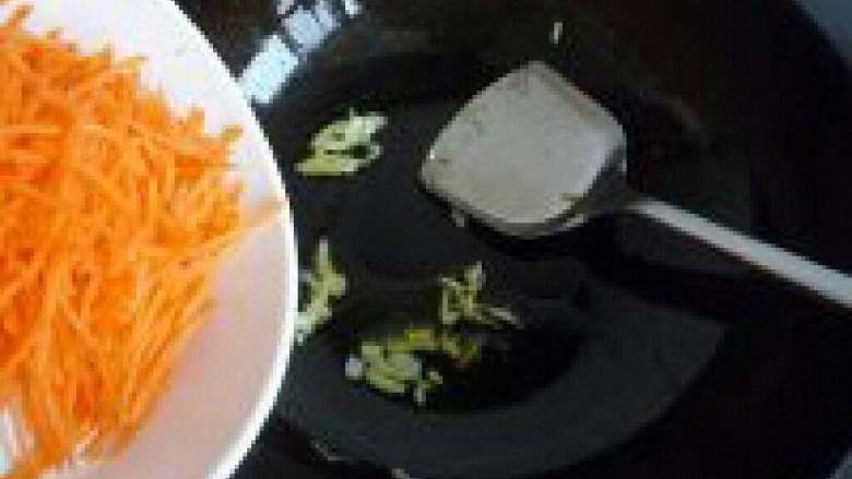 胡萝卜丝炒鸡蛋,锅里放油把葱白放进去爆香,在把胡萝卜倒进去翻炒。
