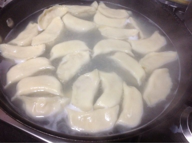 小清新-豆角馅饺子,水烧开,加入包好的饺子,用饭勺反过来顺着锅边下去把饺子伴开,以防粘锅。大火烧开,文火烧只饺子肚子涨大,即表明饺子熟了。