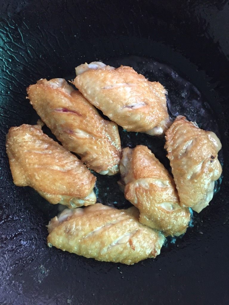 香酥鸡翅,如图油开时放入腌制好的鸡翅煎至两面金黄色