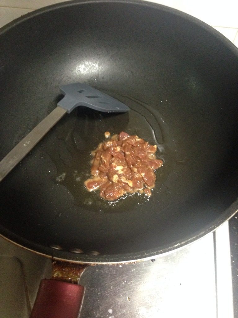 青椒萝卜炒豆干肉丝,如图起锅把腌好的猪肉丝爆炒,爆炒至微焦,加入少量水。装盘待用。