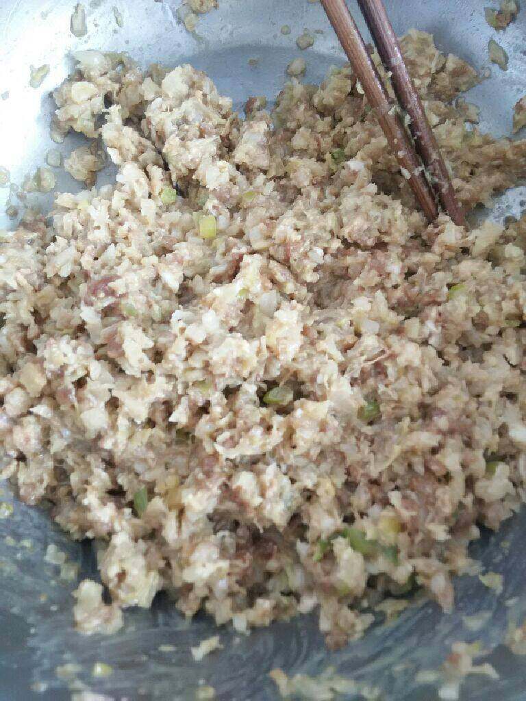 酸菜猪肉馅饺子,把<a style='color:red;display:inline-block;' href='/shicai/ 414'>猪肉</a>和<a style='color:red;display:inline-block;' href='/shicai/ 3361'>酸菜</a>（水分攥干）剁碎成馅料后加入油，盐，<a style='color:red;display:inline-block;' href='/shicai/ 756'>鸡精</a>，<a style='color:red;display:inline-block;' href='/shicai/ 692'>酱油</a><a style='color:red;display:inline-block;' href='/shicai/ 718'>料酒</a><a style='color:red;display:inline-block;' href='/shicai/ 10404'>花椒面</a>，葱花向一个方向搅拌均匀，如果馅料很干，就少放入些水，搅拌至可以听到哗哗的响声，如图馅料就做好了