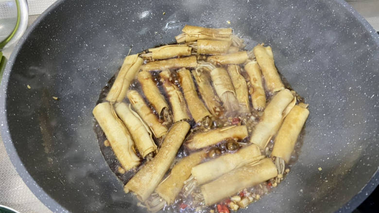 金针菇豆皮卷,倒入料汁,煮开