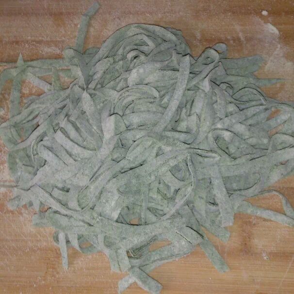 菠菜素哨子面,将擀好的面像折扇子一样,折起来切成面条。
