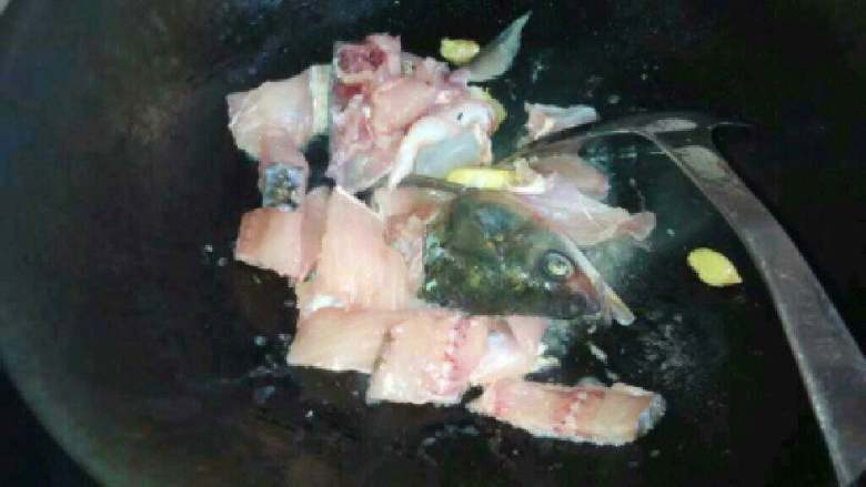 自制【酸菜鱼】,放入鱼头和鱼头上的肉翻炒。