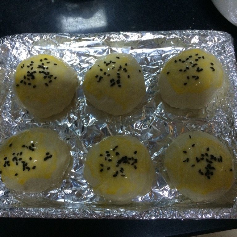 黑椒牛肉餐包,如图捏紧封口,二次醒发半个小时,刷上蛋液,撒上黑芝麻