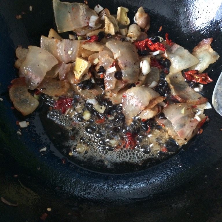 豉椒腊肉,如图肉片卷边下入葱姜辣椒炒香