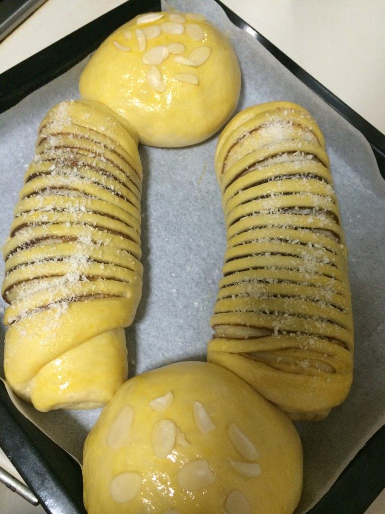 毛毛虫面包,如图把剩下的3分之1蛋液用羊毛刷涂在面包表面,洒上椰丝;