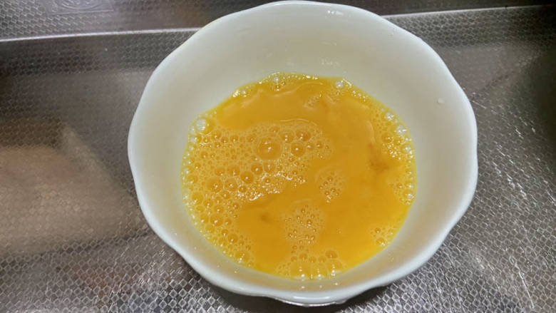 火腿青菜炒鸡蛋,鸡蛋加少许盐,搅打成均匀蛋液