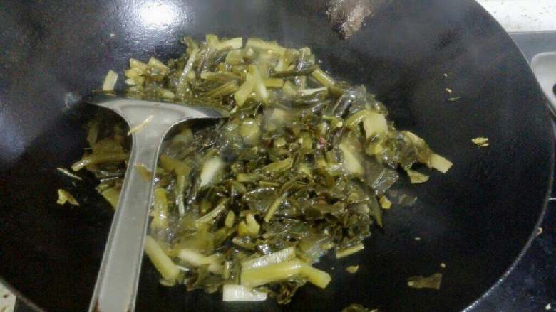 酸菜粉丝汤,锅里倒适量油,烧热后倒入酸菜泡椒和姜末花椒炒香。