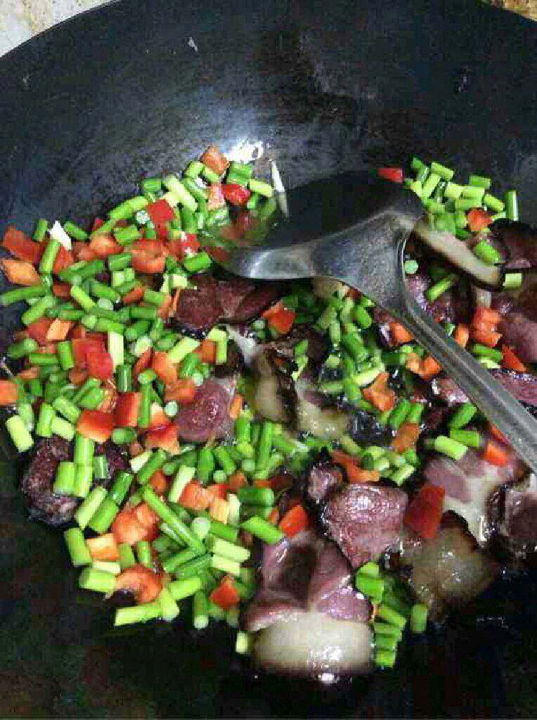 自创【蒜苔炒腊肉】,在倒进红辣椒翻炒,撒一点点盐在蒜苔和辣椒上,然后继续翻炒到熟后盛出。